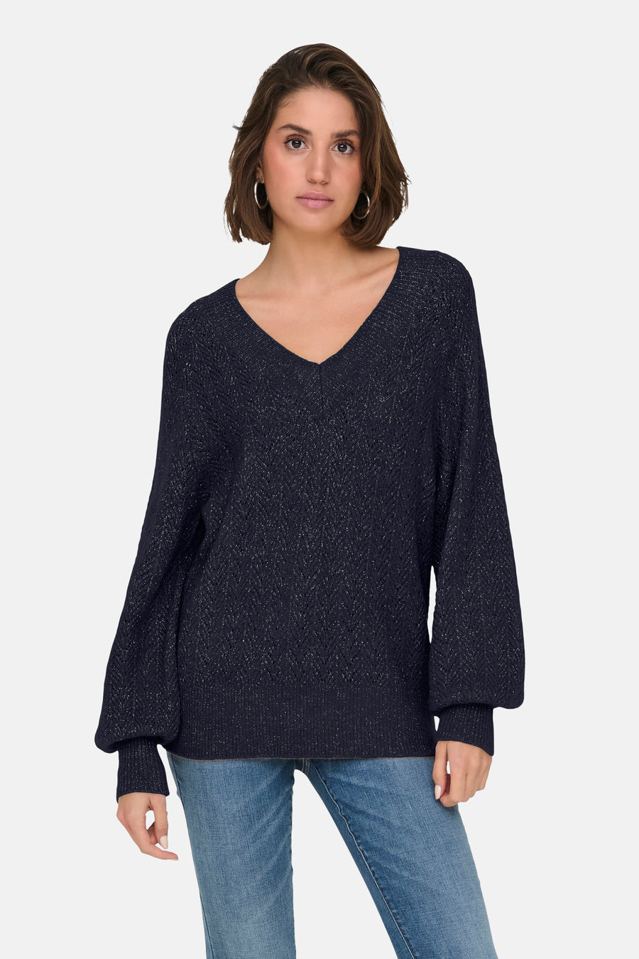 Pull bleu à col en V de ONLY®, avec manches bouffantes et détails scintillants, porté avec un jean décontracté.
