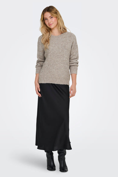 Pull à col rond beige de ONLY, porté avec une longue jupe noire et des bottes en cuir.