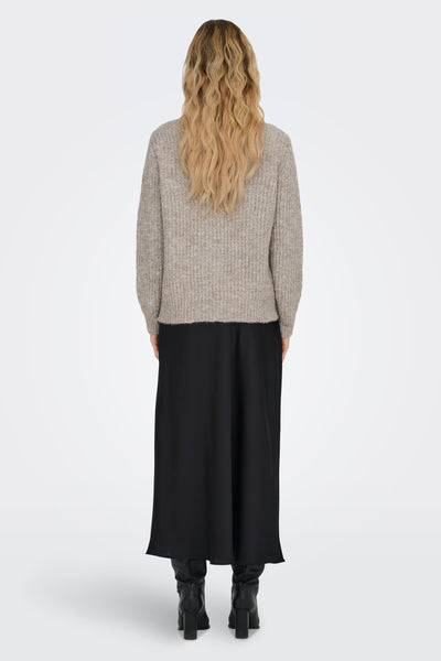 Pull à col rond beige de ONLY®, porté avec une jupe noire longue et des bottes en cuir noir.