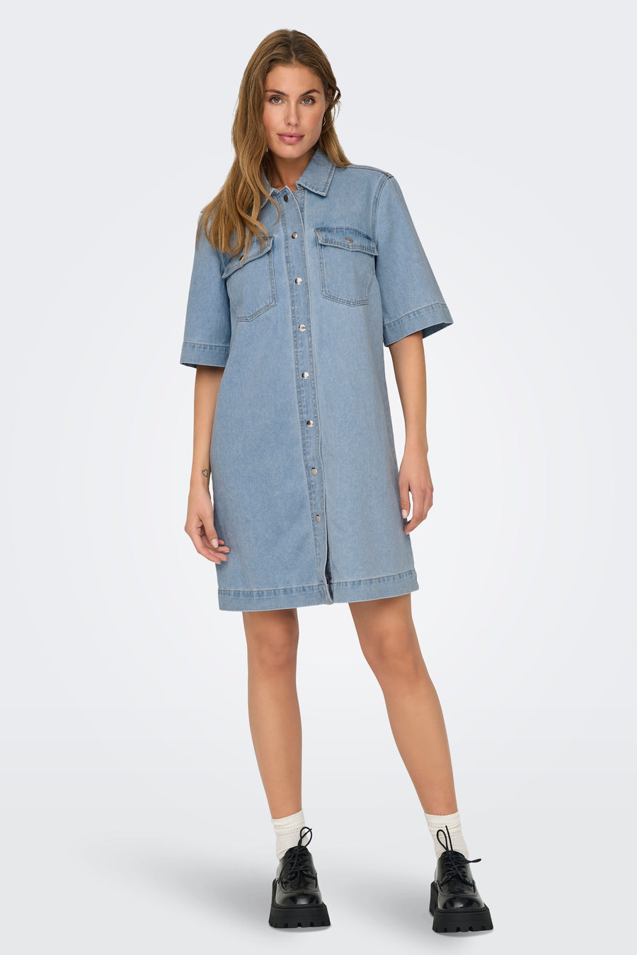 Robe en denim bleu clair de ONLY, avec manches courtes, poches poitrine et fermeture boutonnée sur le devant.
