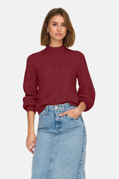Pull à col roulé bordeaux de ONLY®, avec des motifs tressés et porté avec une jupe en jean.
