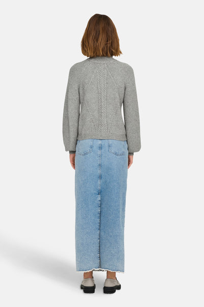 Grijze coltrui van ONLY, met kabelpatroon op de rug, gedragen met een lange blauwe spijkerrok.