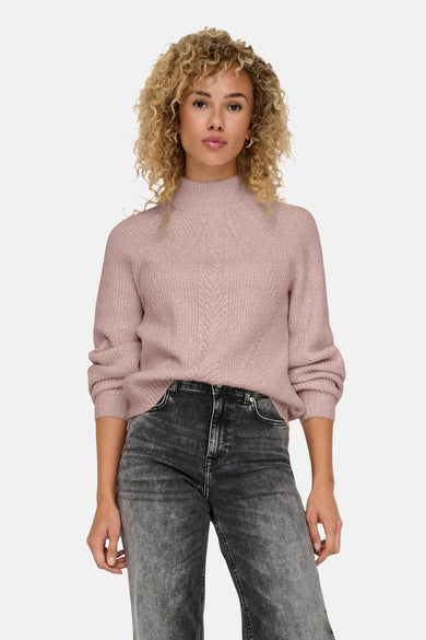 Pull à col roulé rose ONLY® avec un motif tressé et porté avec un jean délavé.
