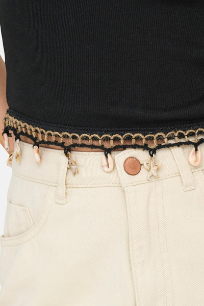 Top sans manches noir de ONLY, porté avec une ceinture décorative à coquillages sur un jean écru.