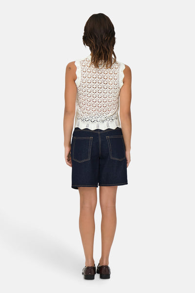 Top sans manches beige de JDY, en crochet ajouré, porté avec un short en jean bleu foncé.