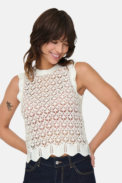 Top beige sans manches by JDY avec motif ajouré, porté avec un jean bleu foncé.