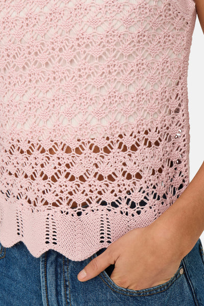 Top rose sans manches de JDY, en maille ajourée, porté avec un jean bleu.
