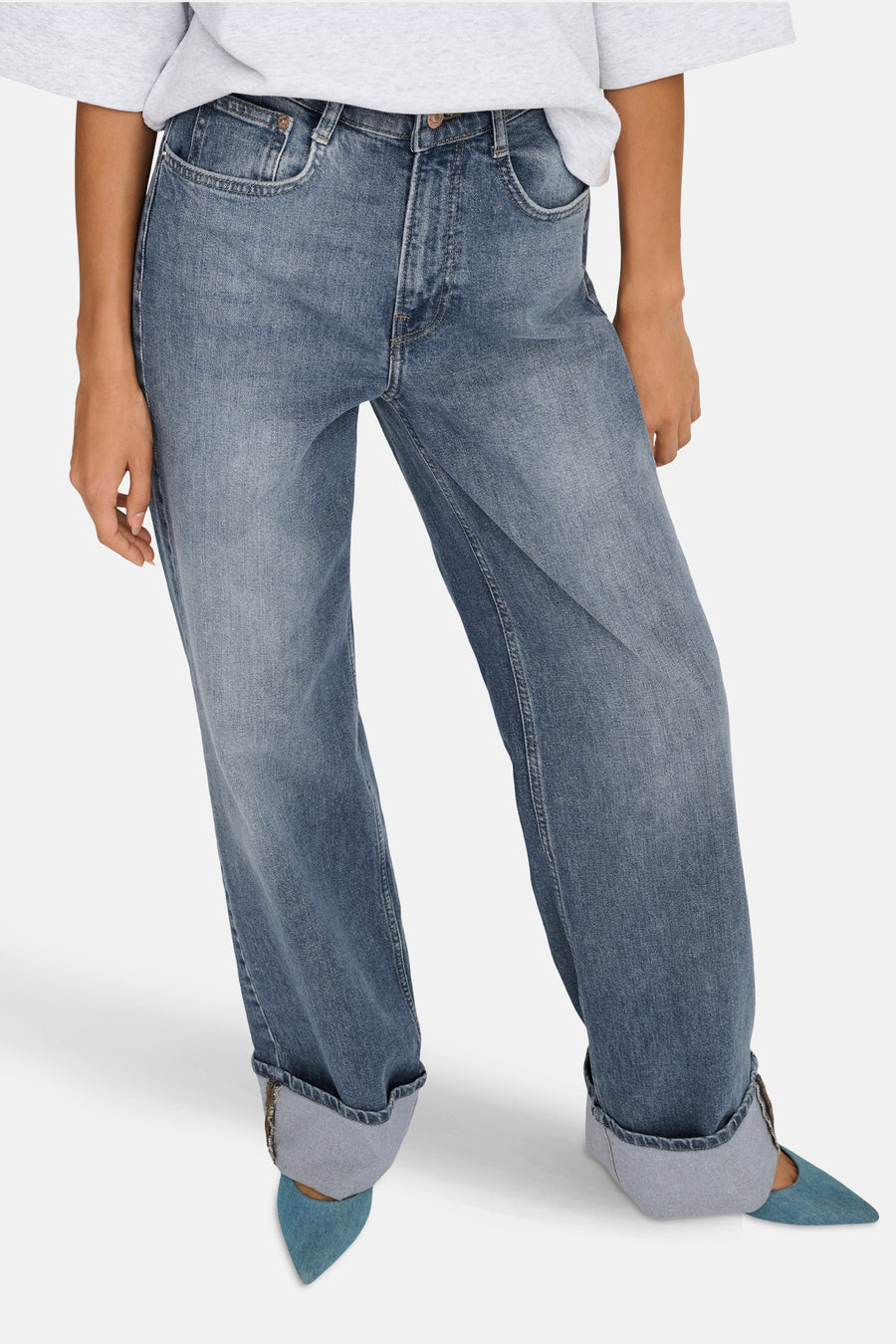 Wijde spijkerbroek in middieblauw denim van ONLY, met omgeslagen zomen en blauwe puntige schoenen.