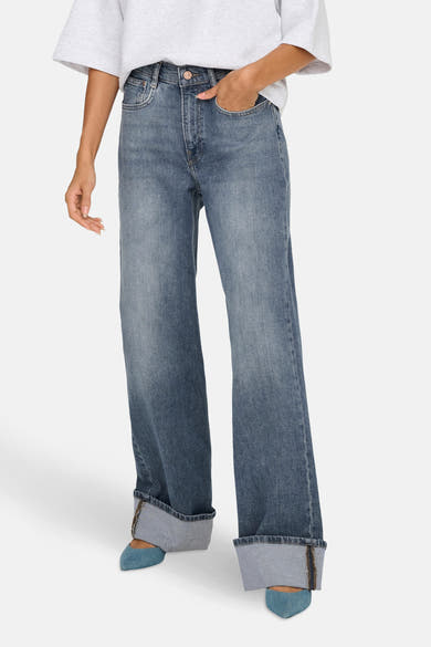 Middelblauwe wijde jeans van ONLY, met omgeslagen zomen en gedragen met blauwe pumps.