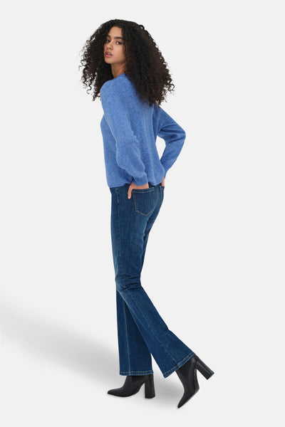 Cardigan bleu de JDY, porté avec un jean et des bottines noires à talons.