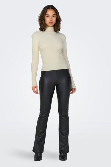 Pull à col roulé beige de JDY, porté avec un pantalon noir en similicuir.
