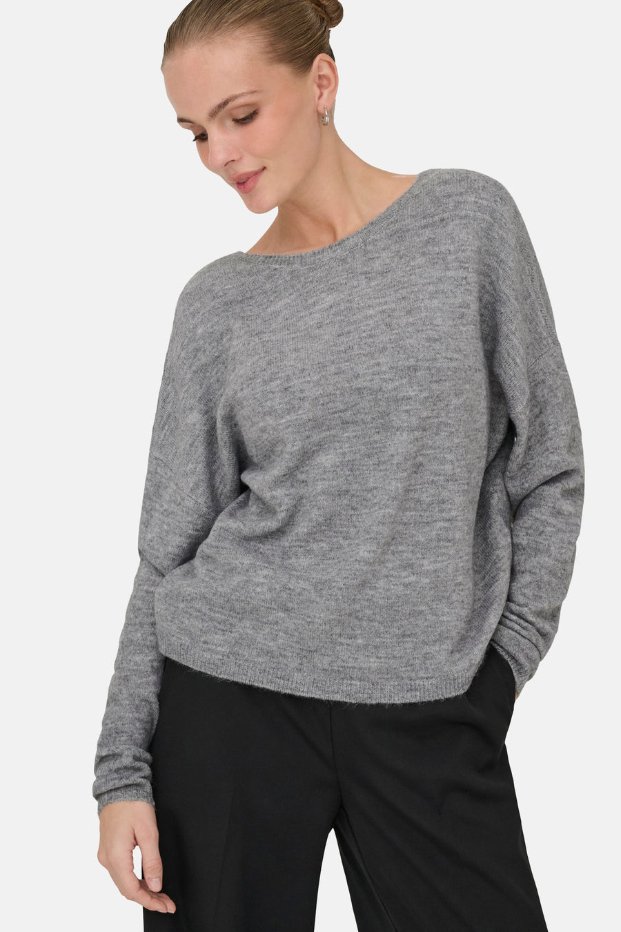 Grijze V-hals trui van ONLY, gedragen met een zwarte broek, op een lichte achtergrond.