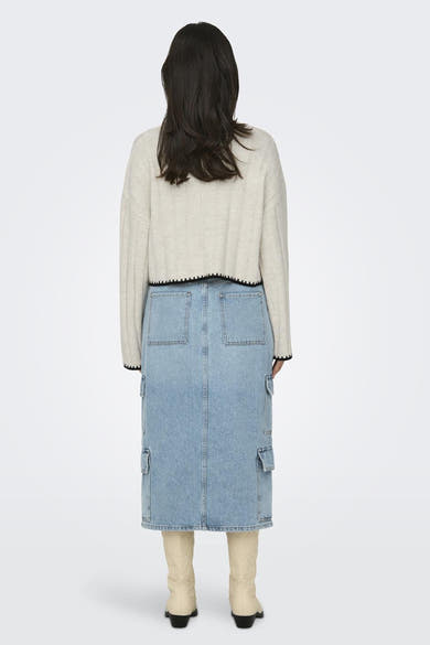 Pull écru à col roulé de ONLY, orné d'une bordure festonnée noire, porté avec une jupe en jean cargo.