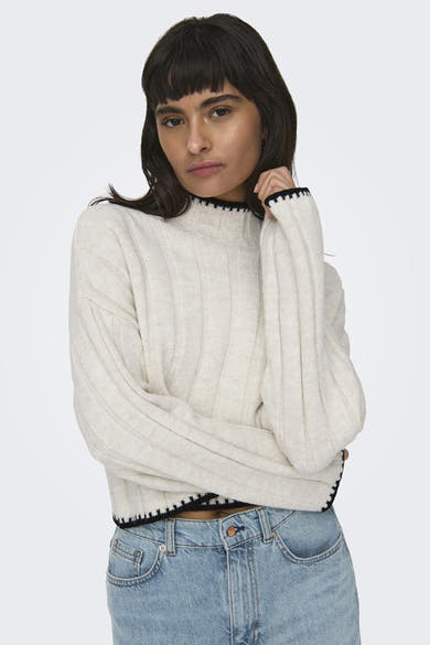 Pull à col roulé écru de ONLY, avec bordure noire contrastante et texture côtelée, porté avec un jean taille haute.