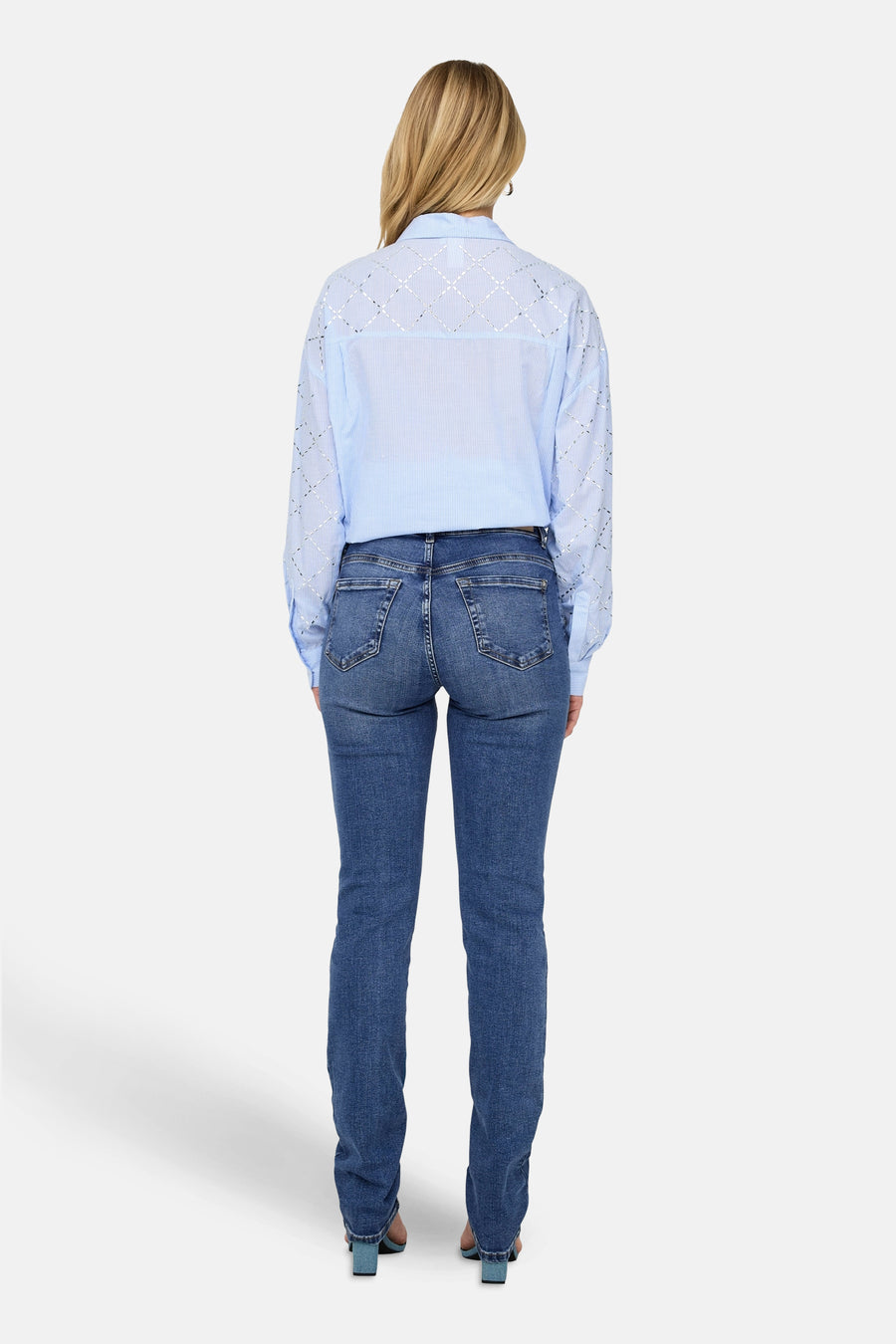 Slim jeans in medium blue denim van ONLY®, van achteren getoond, gedragen met een gestreept overhemd en blauwe hakken.