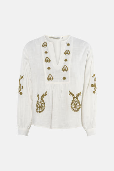 Wit blouse met lange mouwen van ONLY, met bloemenborduursel, gedragen met een beige minirok en naaldhakken.