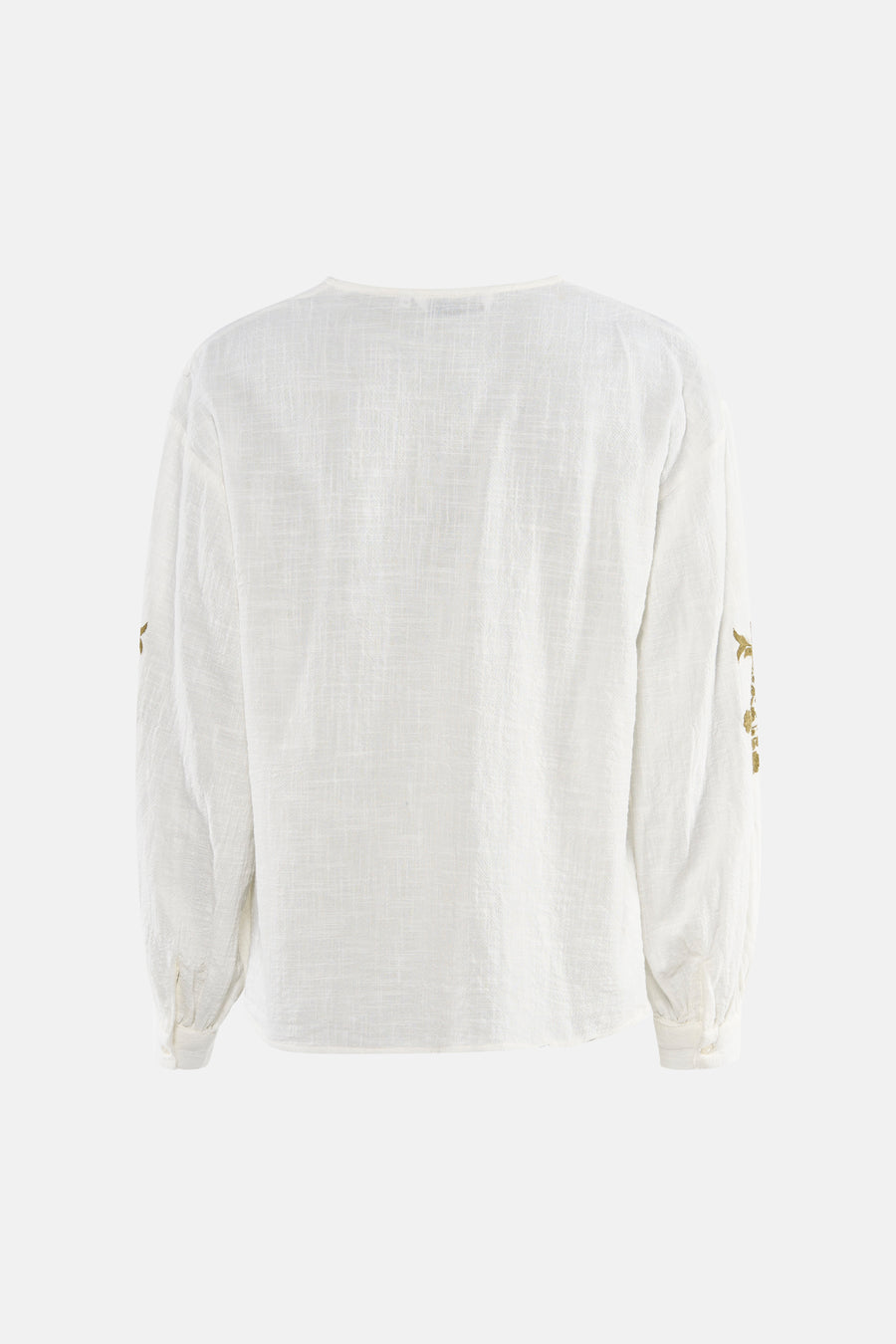 Blouse blanche à manches longues de ONLY, avec broderie florale dorée sur les manches.

