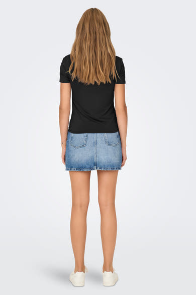 Zwart T-shirt van ONLY®, gedragen met een korte spijkerrok en gebroken witte sneakers.