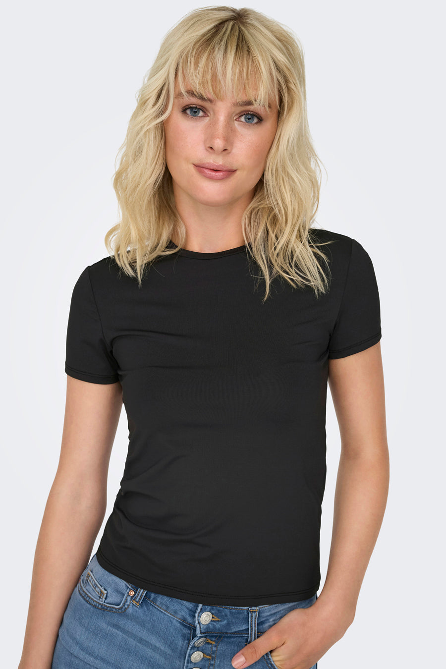 Effaatzwart T-shirt met korte mouwen van ONLY, gedragen met een lichtblauwe spijkerbroek met knopen.