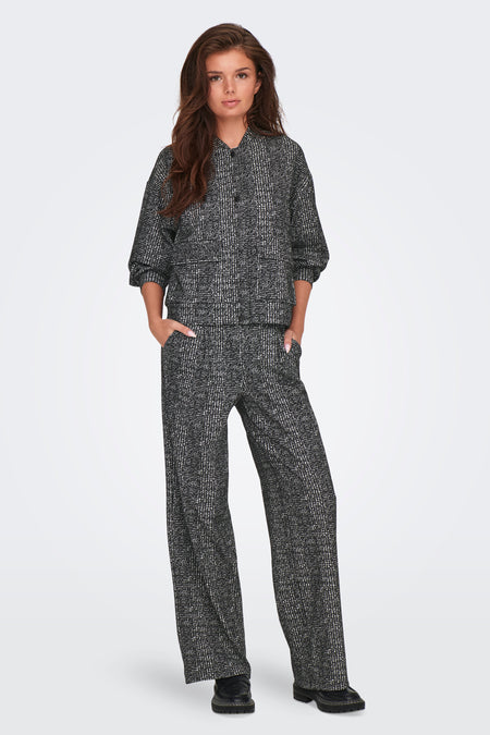 Pantalon coloré gris de JDY, à motif quadrillé, porté avec un haut assorti et des chaussures noires.