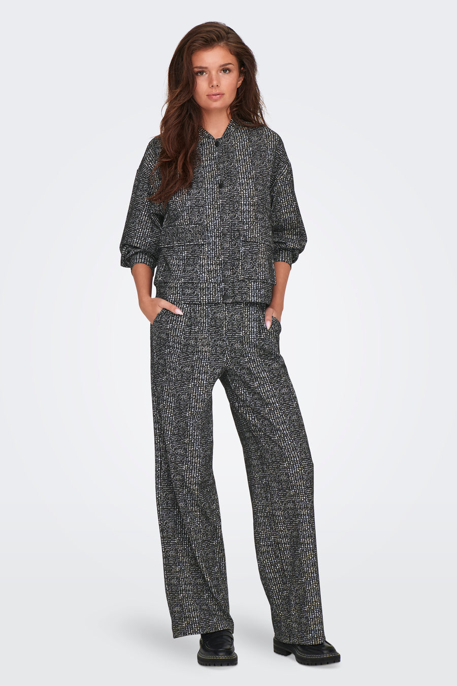 Pantalon coloré gris de JDY, à motif quadrillé, porté avec un haut assorti et des chaussures noires.