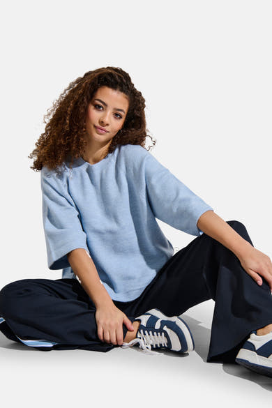 Ronde hals trui blauw van ONLY, gedragen met een donkere broek en witte sneakers.