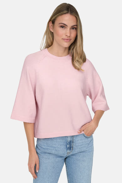 Roze trui met ronde hals van ONLY®, gedragen met een lichtblauwe jeans.