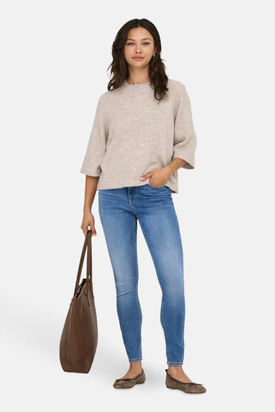 Beige ronde hals trui van ONLY, gedragen met een blauwe spijkerbroek en bruine ballerina's.