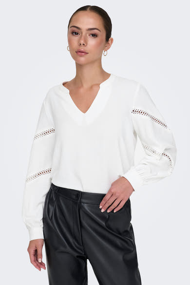 Wit overhemd met lange mouwen en V-hals van JDY, met uitgesneden details op de mouwen, gedragen met een zwarte broek.