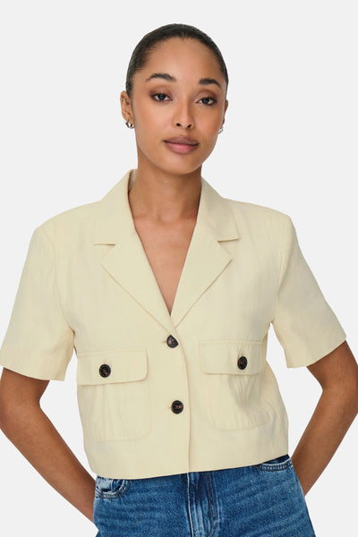 Beige overhemd met korte mouwen van JDY met opgestikte zakken, gedragen met een blauwe jeans.