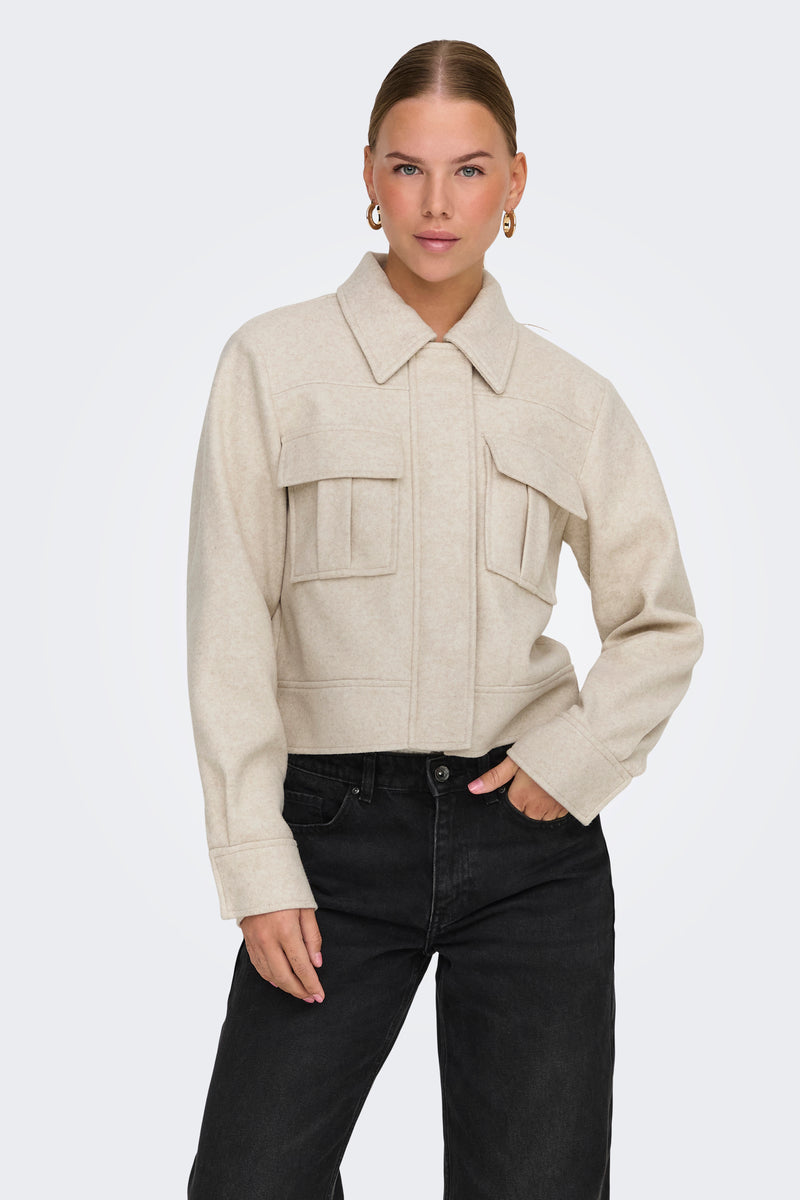 Veste courte écru de ONLY, avec poches à rabat, portée avec un jean noir.