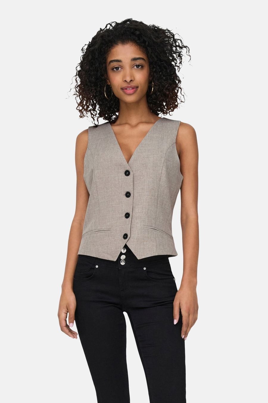 Beige blazer, mouwloos ONLY®, gedragen over een zwarte high-waist jeans.