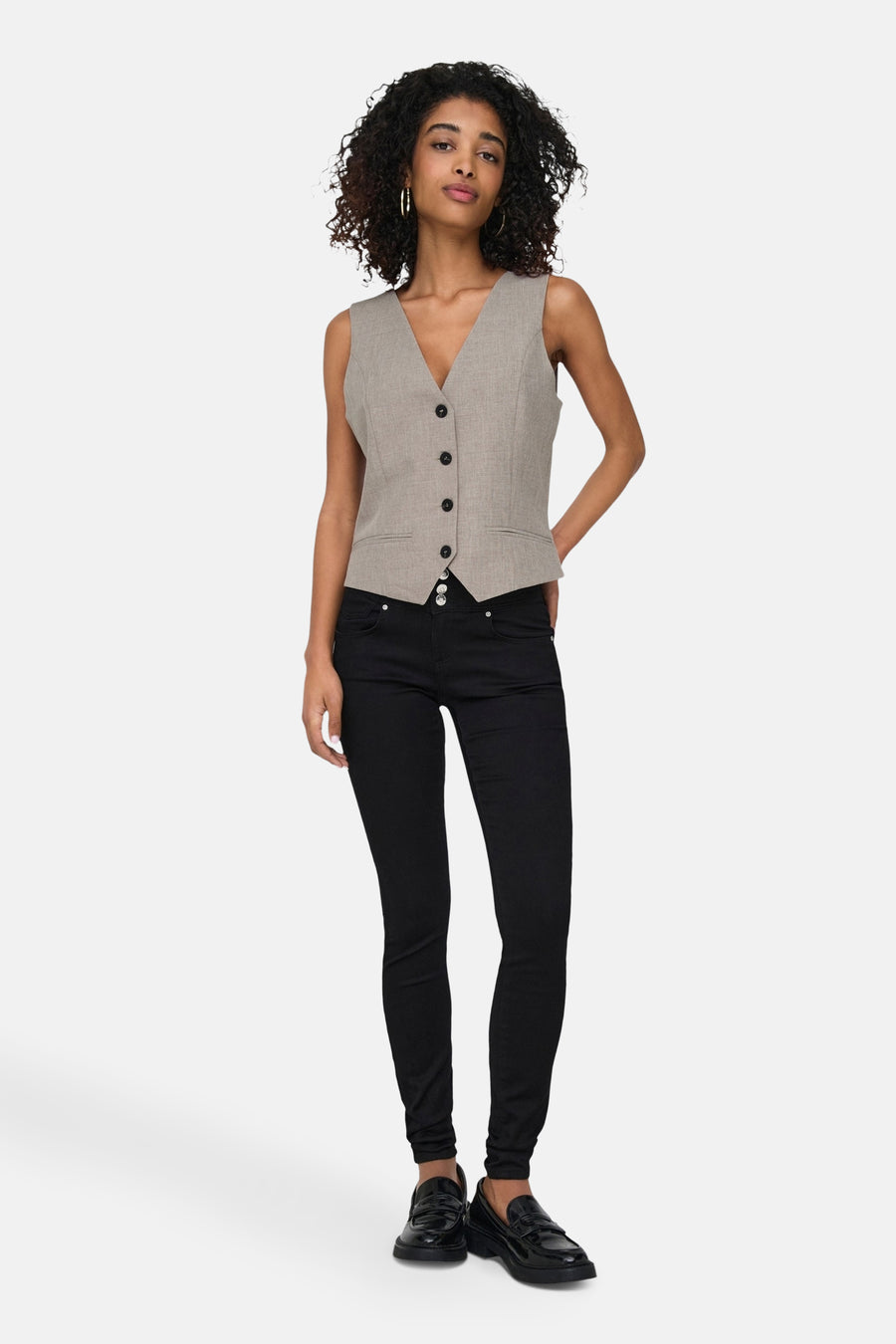 Beige mouwloze blazer van ONLY, gedragen met een zwarte broek en loafers.