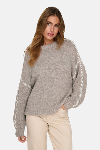 Pull à col rond beige de JDY avec des coutures décoratives sur les manches, porté avec un pantalon beige.
