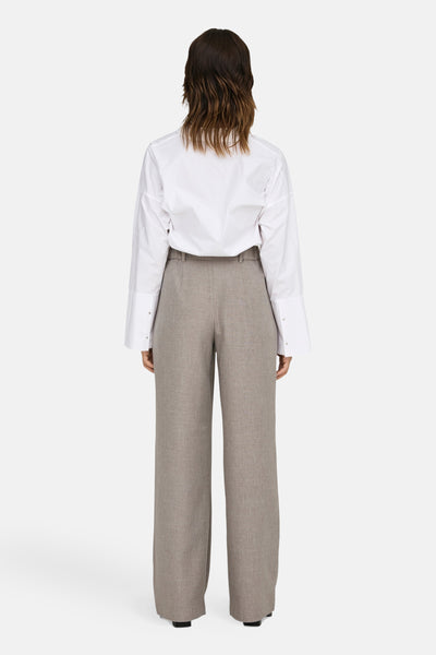 Pantalon de costume beige de ONLY, ample, avec une chemise blanche à manches longues et des boutons.