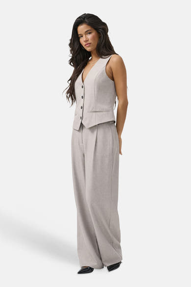 Pantalon de costume beige ONLY® coupe ample, porté avec un veston assorti sans manches.