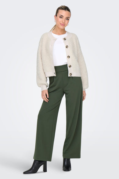 Cardigan écru en maille bouclée de JDY, porté sur un t-shirt blanc et un pantalon vert olive.