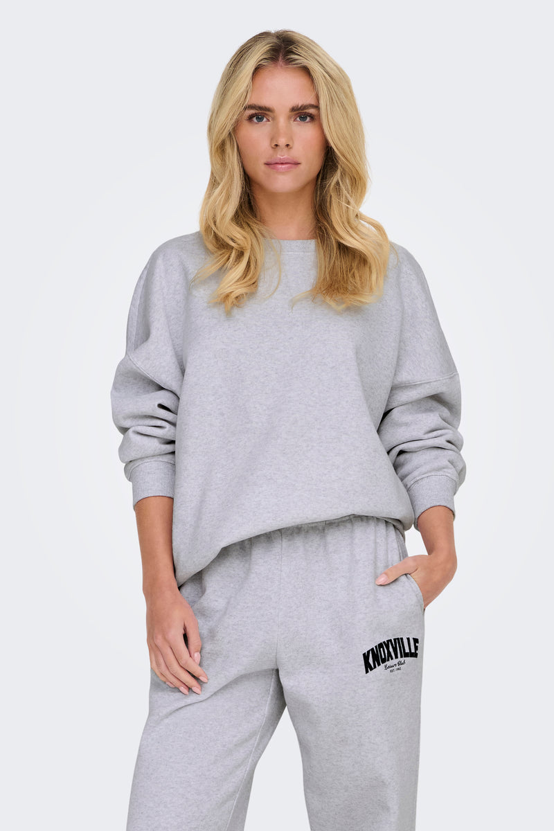 Grijze rondehals sweatshirt van ONLY®, gedragen door een vrouw, met lange mouwen en een rechte zoom.