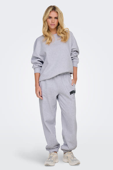 Sweat col rond gris par ONLY®, porté par une femme, avec des manches longues et un ourlet droit.