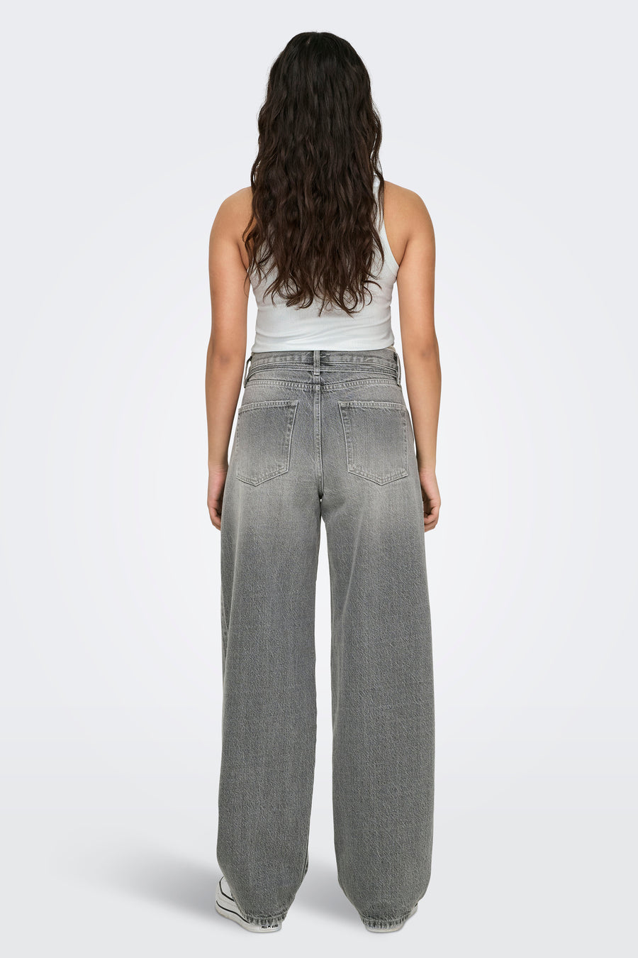 Jean droit en denim gris moyen de ONLY, porté avec un débardeur blanc, vue de dos.
