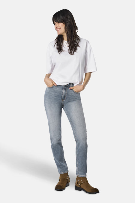 Jean Mom bleu moyen par ONLY®, porté avec un t-shirt blanc et des bottines marron.