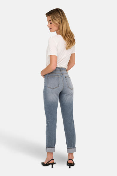Jean Mom en denim bleu moyen de ONLY, porté avec un t-shirt blanc et des escarpins noirs.
