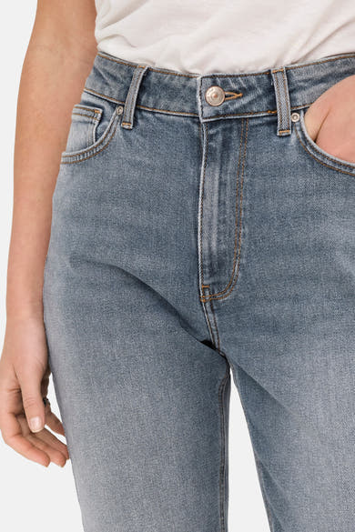 Jean mom en denim bleu moyen de ONLY, avec une texture subtile et une main dans la poche.
