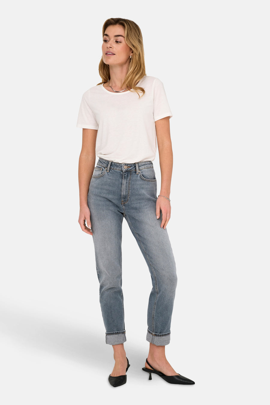 Jean Mom bleu moyen de ONLY, porté avec un t-shirt blanc et des talons aiguilles noirs