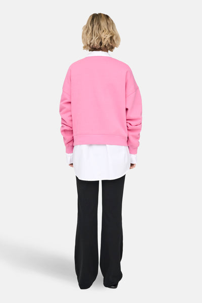Sweat met ronde hals van ONLY®, gedragen met een wit overhemd en een zwarte uitlopende broek, van achteren gezien.