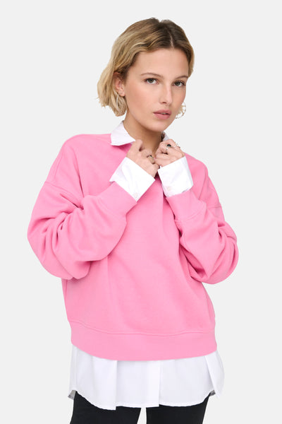 Roze sweatshirt van ONLY, gedragen over een wit overhemd met contrasterende kraag en manchetten