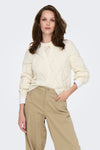 Pull écru à col rond de ONLY, motif losanges ajourés, porté avec un pantalon chino beige.
