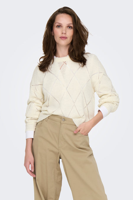 Ecru trui met ronde hals van ONLY, opengewerkt ruitpatroon, gedragen met een beige chino broek.