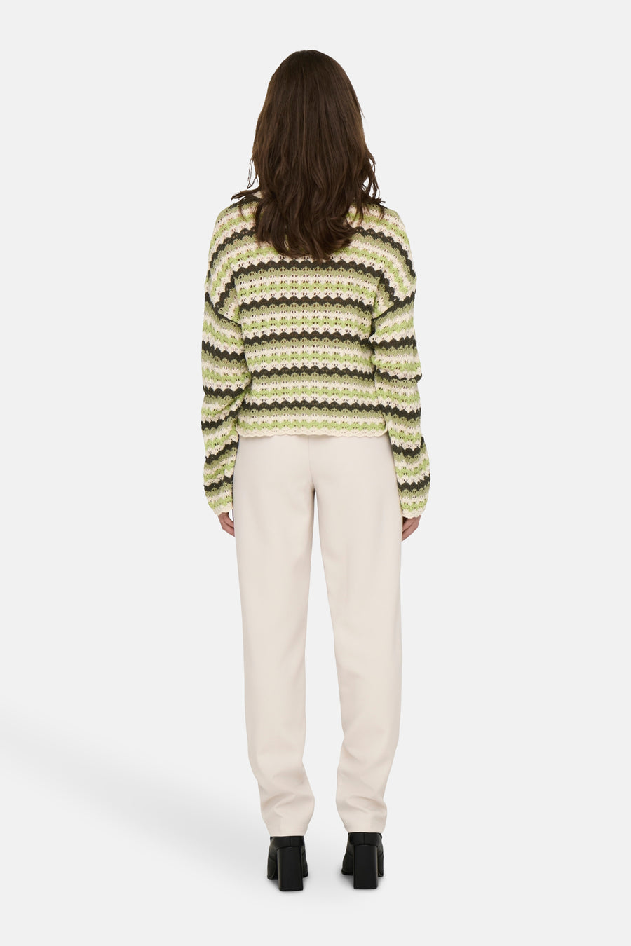 Pull à col rond multicolore de ONLY®, avec un motif rayé et porté avec un pantalon beige.
