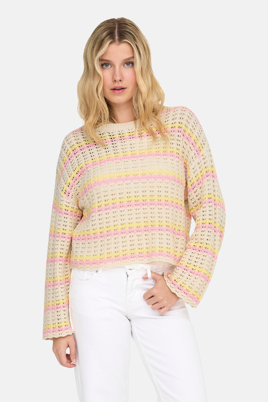 Pull multicolore à rayures par ONLY®, porté avec un pantalon blanc.

